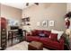 Comfortable living area with desk, floating shelves, burgundy sofa, and ottoman at 3535 E Brookwood Ct, Phoenix, AZ 85048