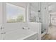 Bright bathroom showcasing a soaking tub, a large window, and a glass-enclosed shower at 3575 E Gary Way, Gilbert, AZ 85234