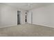 Spacious bedroom featuring neutral carpeting, a ceiling fan, and entryways into closet and bath at 3575 E Gary Way, Gilbert, AZ 85234