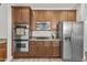 Gourmet kitchen showcasing stainless steel appliances, rich wood cabinets, and granite countertops at 3575 E Gary Way, Gilbert, AZ 85234
