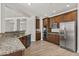 Modern kitchen with granite countertops, stainless steel appliances, and wood cabinets, open to the living area at 3575 E Gary Way, Gilbert, AZ 85234