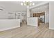 Open-concept living room with light wood-look flooring that flows into the kitchen with stainless steel appliances at 3575 E Gary Way, Gilbert, AZ 85234