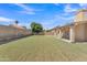 Expansive backyard features a well-maintained lawn, block fence, and covered patio, perfect for outdoor entertaining at 3882 S Hawthorn Dr, Chandler, AZ 85248