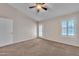 Bright bedroom featuring a ceiling fan, neutral carpet, and door to a patio at 3882 S Hawthorn Dr, Chandler, AZ 85248