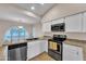 Bright kitchen with stainless steel appliances, white cabinets, and a sink with a large window for natural light at 3882 S Hawthorn Dr, Chandler, AZ 85248