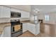 Bright kitchen featuring stainless steel appliances, granite counters, and access to the living room with fireplace at 3882 S Hawthorn Dr, Chandler, AZ 85248