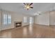 Spacious living room boasts wood-look tile flooring, a fireplace, ceiling fans, and a sliding glass door to the backyard at 3882 S Hawthorn Dr, Chandler, AZ 85248
