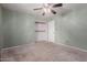 A cozy carpeted bedroom with a ceiling fan and a closet with shelving for ample storage at 428 S Sunnyvale --, Mesa, AZ 85206
