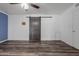 This spacious bedroom features stylish wood-look floors, a ceiling fan, and a rustic barn door at 428 S Sunnyvale --, Mesa, AZ 85206