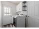 A bright laundry room with modern white washer and dryer, shelving, and convenient exterior access at 428 S Sunnyvale --, Mesa, AZ 85206