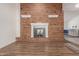 Cozy living room with a striking red brick fireplace and wood flooring, creating a warm and inviting space at 428 S Sunnyvale --, Mesa, AZ 85206