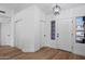 Bright foyer with wood-look floors, a modern light fixture, and a convenient coat closet at 4439 W Cielo Grande --, Glendale, AZ 85310