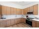 Modern kitchen boasts stainless steel appliances, tile backsplash, and light wood cabinets at 4439 W Cielo Grande --, Glendale, AZ 85310