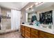 Bathroom featuring double sinks, large mirrors, shower, and plenty of storage space at 5354 E Ellis St, Mesa, AZ 85205