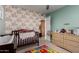 Charming Bedroom features floral wallpaper, baby furniture, and a peek into an adjacent room at 5354 E Ellis St, Mesa, AZ 85205