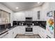 Modern kitchen featuring white cabinets, black countertops, and stainless steel appliances at 5354 E Ellis St, Mesa, AZ 85205