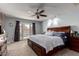 Comfortable main bedroom featuring a large bed, ceiling fan, and access to the backyard at 5354 E Ellis St, Mesa, AZ 85205