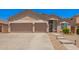 A home with a spacious three car garage and desert landscaping in front at 9142 W Pontiac Dr, Peoria, AZ 85382
