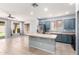 Open concept kitchen with blue cabinets, center island, stainless appliances, and tile floors at 9142 W Pontiac Dr, Peoria, AZ 85382