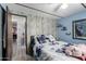 Cozy bedroom featuring blue accents, soft lighting, and unique wood-look wall design at 9302 E Broadway Rd # 122, Mesa, AZ 85208