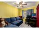 Bedroom with yellow walls, a blue sofa, and a desk area at 9302 E Broadway Rd # 122, Mesa, AZ 85208
