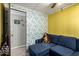 Cozy living room featuring a comfortable blue sofa with a floral accent wall at 9302 E Broadway Rd # 122, Mesa, AZ 85208