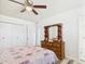 This bedroom features a ceiling fan, closet, wood-look flooring, and a dresser with a mirror at 9915 W Mountain View Rd, Sun City, AZ 85351