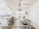Cozy dining area featuring a white table set, wood-look floors, and a view of the breakfast bar at 9915 W Mountain View Rd, Sun City, AZ 85351