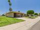 Charming single-story home boasting lush green lawn, mature landscaping, and a covered carport at 9915 W Mountain View Rd, Sun City, AZ 85351