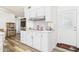 Updated kitchen featuring white cabinets, stainless steel appliances, and a modern backsplash at 9915 W Mountain View Rd, Sun City, AZ 85351