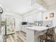 Bright kitchen featuring white cabinets, stainless appliances, and a convenient breakfast bar at 9915 W Mountain View Rd, Sun City, AZ 85351