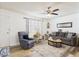 Cozy living room showcasing wood-look floors, a plush sofa, and ample natural light from a window at 9915 W Mountain View Rd, Sun City, AZ 85351