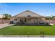Expansive backyard featuring artificial grass and a covered patio with comfortable seating and a dining table at 1030 S Brentwood Ct, Chandler, AZ 85286
