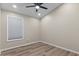 Neutral-toned bedroom with a modern ceiling fan, light wood floors, and a large window with blinds at 1030 S Brentwood Ct, Chandler, AZ 85286