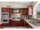 This is a kitchen featuring dark cabinetry, granite counters, and stainless appliances at 1030 S Brentwood Ct, Chandler, AZ 85286