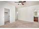 Spacious bedroom with a ceiling fan, closet, and attached bathroom with wood cabinets and a large mirror at 1086 E Canyon Trail --, San Tan Valley, AZ 85143