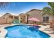 Sparkling pool with a red umbrella, two patio chairs, and lots of beautiful greenery at 1086 E Canyon Trail --, San Tan Valley, AZ 85143
