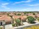 An aerial view captures a neighborhood with uniform homes and well-maintained landscaping under a clear sky at 119 E Camellia Way, San Tan Valley, AZ 85140