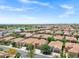 Overhead view of a community with uniform homes, golf course and water features with a clear blue sky at 119 E Camellia Way, San Tan Valley, AZ 85140