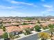 A bird's-eye view captures a well-planned community with uniform housing and desert landscaping under a clear sky at 119 E Camellia Way, San Tan Valley, AZ 85140