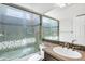 Well-lit bathroom featuring a tiled shower, sink, and stylish mosaic details at 119 E Camellia Way, San Tan Valley, AZ 85140