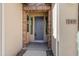 A welcoming front entrance with a gray door surrounded by brick accents at 119 E Camellia Way, San Tan Valley, AZ 85140