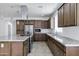 This modern kitchen has updated appliances, stylish cabinetry, and an island cooktop with range hood at 119 E Camellia Way, San Tan Valley, AZ 85140