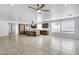 Spacious living room with a modern ceiling fan, bright tile flooring, and an open view to the kitchen at 119 E Camellia Way, San Tan Valley, AZ 85140
