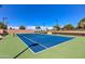 A pristine blue tennis court with green trim provides a great sports and exercise area at 119 E Camellia Way, San Tan Valley, AZ 85140