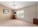 View of the bedroom with neutral walls and carpet, a large window, and simple furnishings at 15073 W Piccadilly Rd, Goodyear, AZ 85395