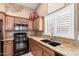 Close-up of the kitchen with stainless steel sink, granite countertops, and black gas stove at 15073 W Piccadilly Rd, Goodyear, AZ 85395