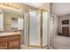 Bathroom view featuring a wooden vanity with a granite countertop, and a glass shower with gold trim at 15073 W Piccadilly Rd, Goodyear, AZ 85395