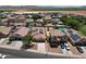 A birds-eye view of a residential neighborhood showing homes, green lawns, desert landscaping, solar panels, and swimming pools at 1623 E Maplewood Ave, Buckeye, AZ 85326