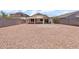 Large backyard featuring gravel, a block wall, and a covered patio at 1623 E Maplewood Ave, Buckeye, AZ 85326